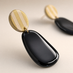 Detalle de los aros Ibiza Black, resina negra de alto brillo y argolla dorada, arcilla polimérica