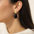 Mujer usando los aros Ibiza Black de PINNA, aros colgantes livianos de 7 cm de largo