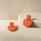 Aros colgantes Málaga Guayaba & Orange sobre piedra travertino, diseño artesanal chileno de PINNA